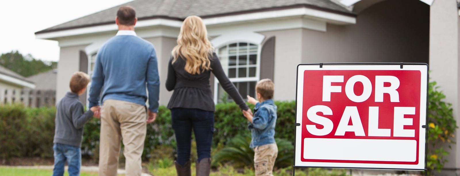 Family standing in front of their new home